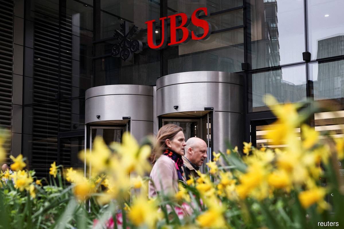 People walk past the entrance of the UBS office in London March 20, 2023. (Reuters pic)